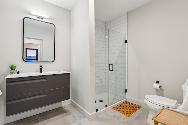 bathroom featuring tile patterned flooring, vanity, toilet, and walk in shower