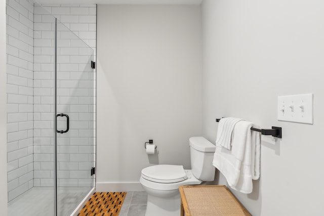 bathroom featuring tile patterned floors, a shower with shower door, and toilet