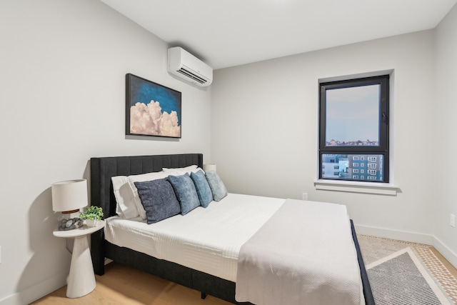 bedroom featuring a wall mounted air conditioner and wood-type flooring