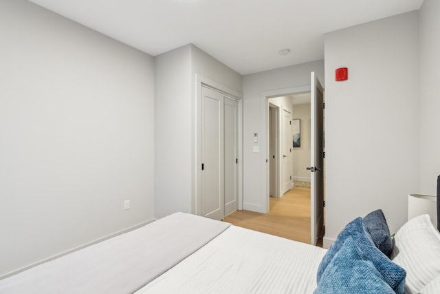 bedroom with a closet and light hardwood / wood-style floors