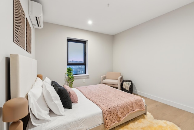 bedroom featuring hardwood / wood-style floors and a wall unit AC