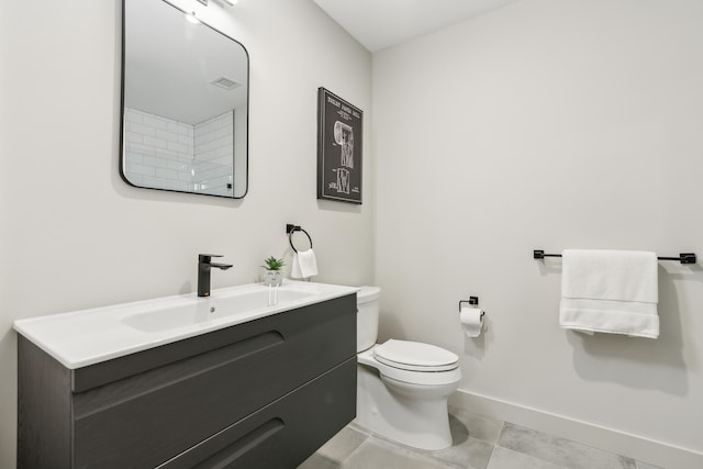 bathroom featuring tile patterned flooring, vanity, and toilet