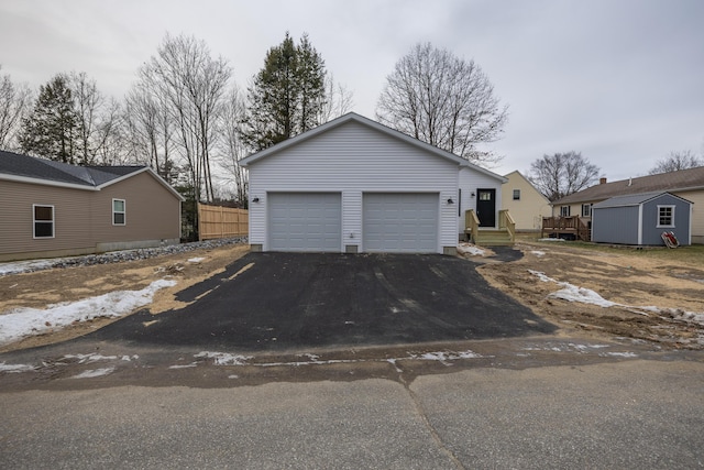 view of front of house with a storage unit, a garage, and a deck