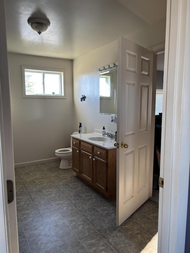 bathroom with vanity, toilet, and plenty of natural light