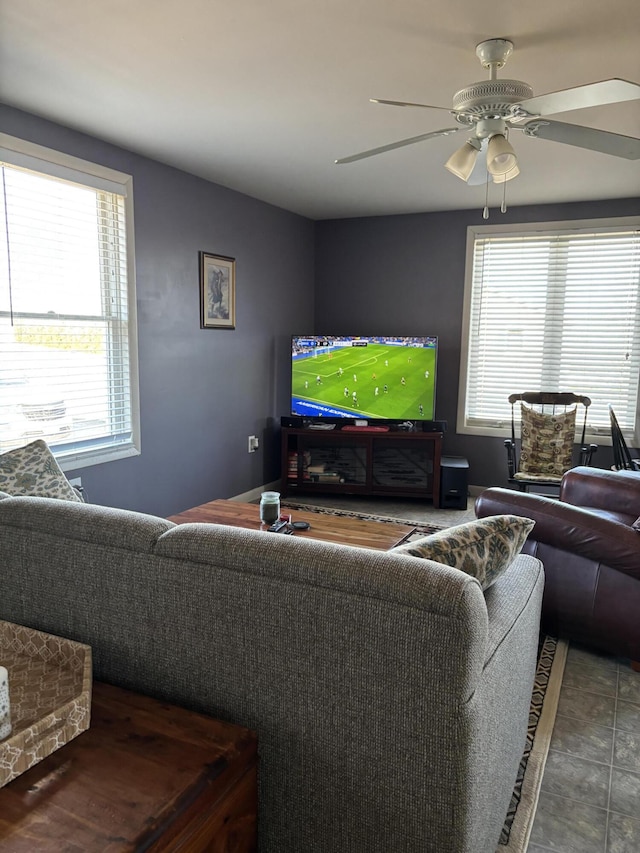 living room featuring ceiling fan and dark tile patterned floors