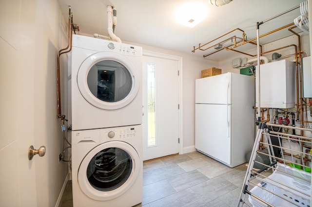 laundry room featuring tankless water heater and stacked washer / drying machine