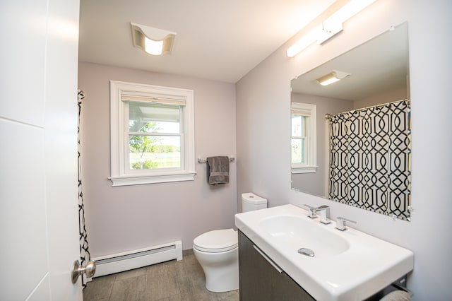 bathroom featuring baseboard heating, vanity, and toilet