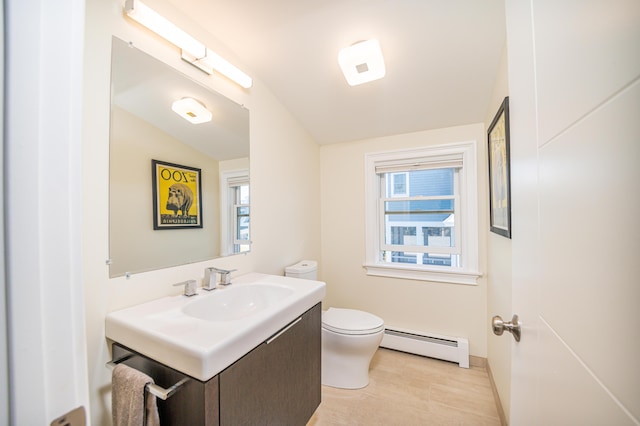 bathroom featuring vanity, a healthy amount of sunlight, toilet, and a baseboard radiator