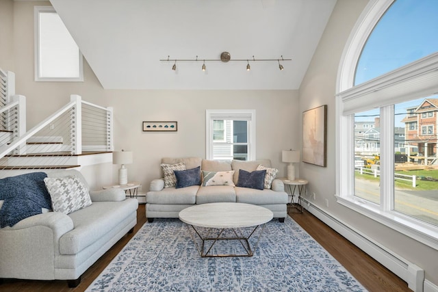 living room featuring dark wood-type flooring, high vaulted ceiling, and a baseboard heating unit