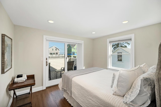 bedroom featuring dark hardwood / wood-style flooring, access to outside, and multiple windows