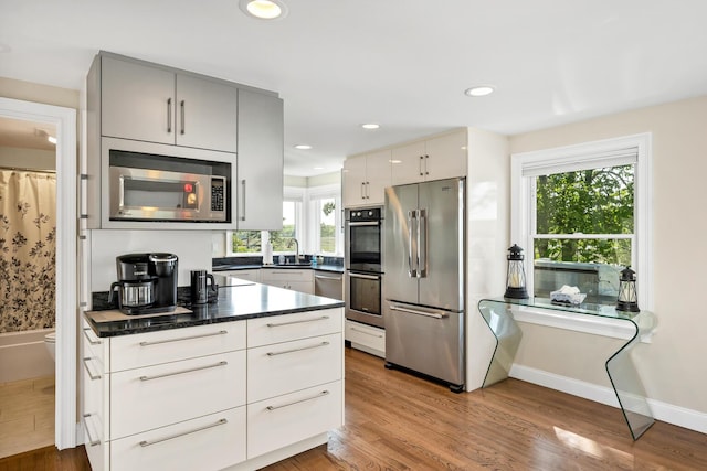 kitchen featuring hardwood / wood-style floors, a wealth of natural light, sink, and stainless steel appliances