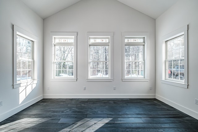 empty room with a wealth of natural light, dark wood-type flooring, and lofted ceiling