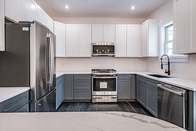 kitchen featuring gray cabinetry, white cabinetry, sink, and stainless steel appliances