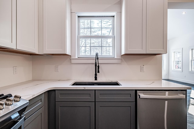 kitchen featuring sink, gray cabinets, appliances with stainless steel finishes, light stone counters, and white cabinetry