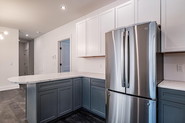 kitchen featuring white cabinets, dark hardwood / wood-style floors, stainless steel fridge, gray cabinets, and kitchen peninsula