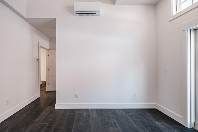 spare room with dark hardwood / wood-style floors and a wall mounted AC