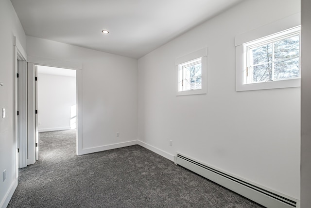 carpeted empty room with a baseboard radiator