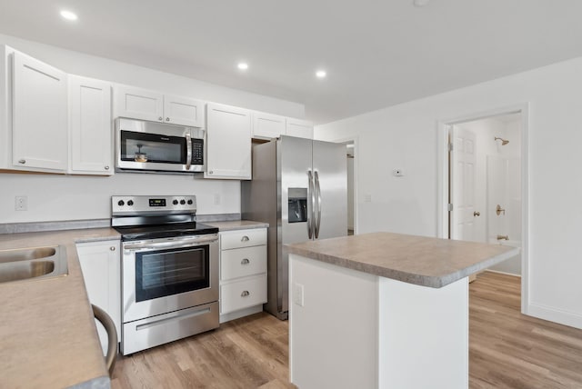 kitchen with light hardwood / wood-style floors, white cabinetry, sink, and appliances with stainless steel finishes