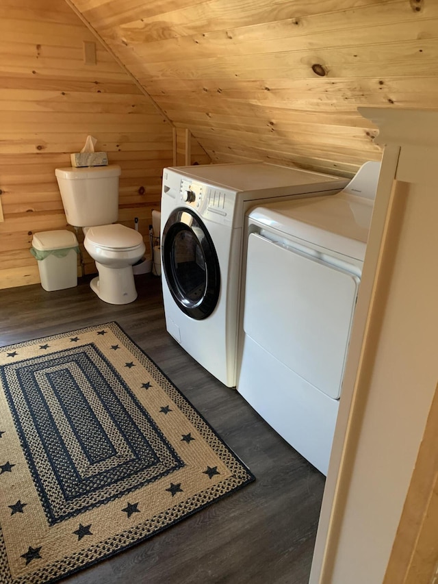 laundry room featuring dark hardwood / wood-style floors, wooden ceiling, wooden walls, and washing machine and clothes dryer