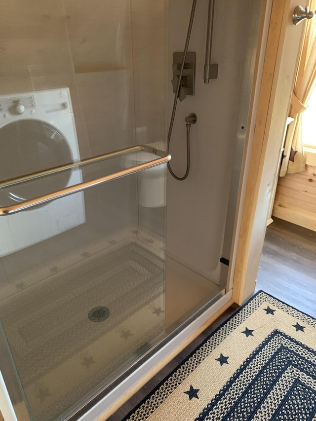 bathroom featuring wood-type flooring and an enclosed shower