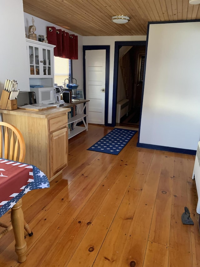 kitchen featuring light brown cabinetry, light hardwood / wood-style floors, radiator, and wooden ceiling