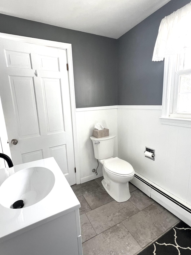 7 Edgewood Dr, Orono, ME 04473 - bathroom featuring toilet, vanity, a baseboard radiator, and wainscoting
