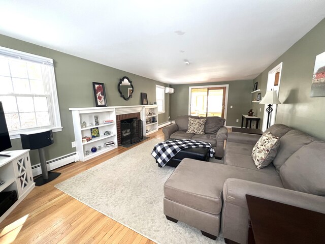 7 Edgewood Dr, Orono, ME 04473 - living area featuring a baseboard radiator, wood finished floors, and a brick fireplace