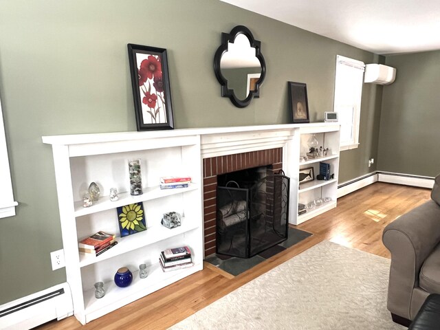 7 Edgewood Dr, Orono, ME 04473 - living room featuring a baseboard radiator, wood finished floors, a fireplace, and a wall mounted air conditioner