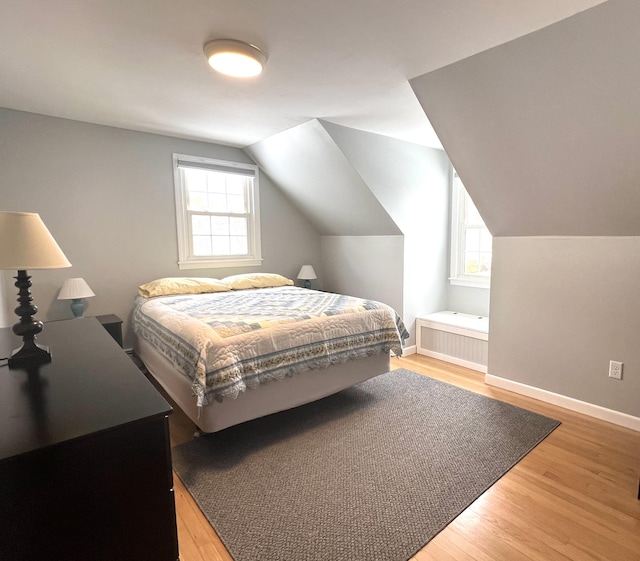 7 Edgewood Dr, Orono, ME 04473 - bedroom with light wood-style flooring, vaulted ceiling, radiator heating unit, and baseboards