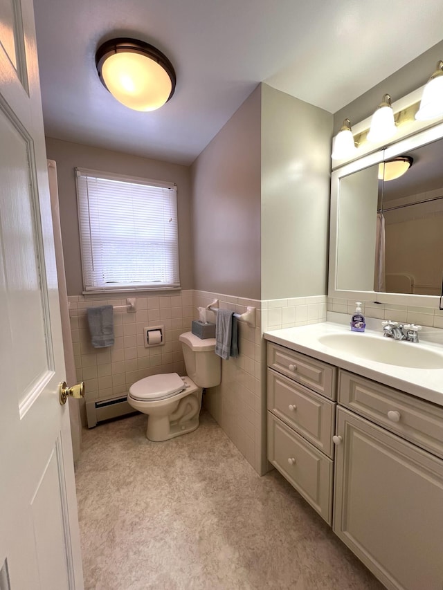 7 Edgewood Dr, Orono, ME 04473 - full bath with baseboard heating, tile walls, toilet, vanity, and a wainscoted wall