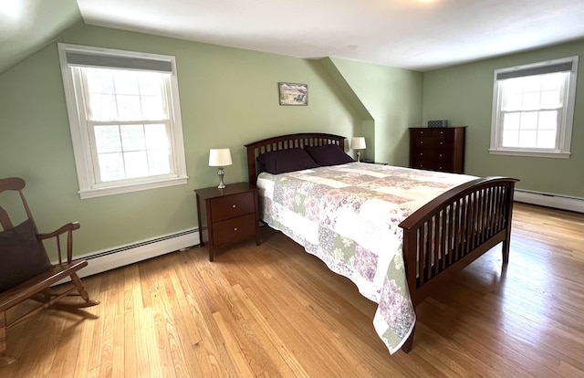 7 Edgewood Dr, Orono, ME 04473 - bedroom featuring a baseboard radiator, wood finished floors, and vaulted ceiling