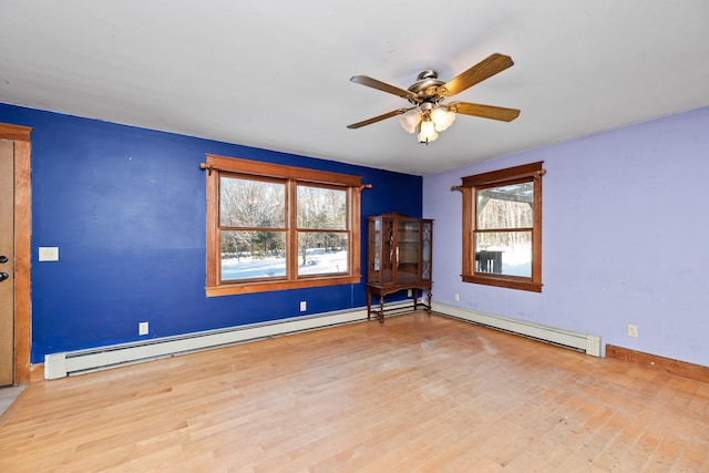 spare room with ceiling fan, baseboard heating, and light hardwood / wood-style flooring