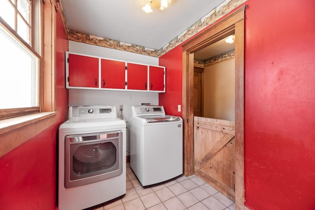 laundry room featuring cabinets, separate washer and dryer, and light tile patterned floors