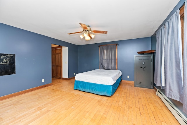 bedroom with a baseboard radiator, ceiling fan, and light hardwood / wood-style floors