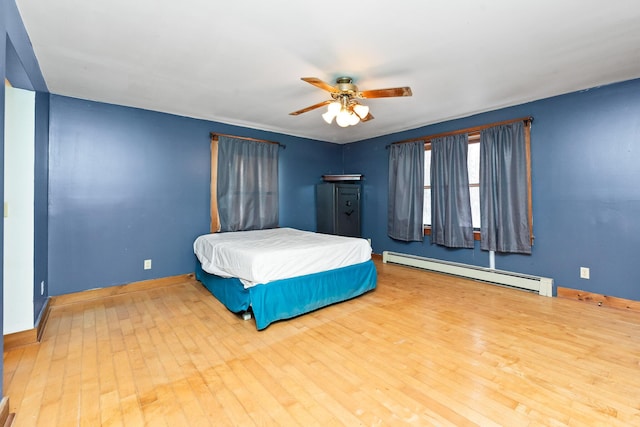 bedroom with wood-type flooring, baseboard heating, and ceiling fan