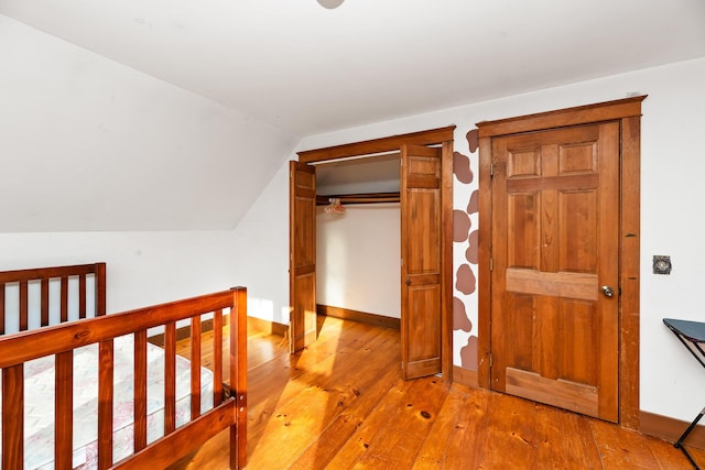 corridor featuring light hardwood / wood-style floors and vaulted ceiling