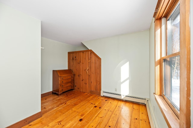 interior space featuring light hardwood / wood-style flooring, a wealth of natural light, and a baseboard heating unit