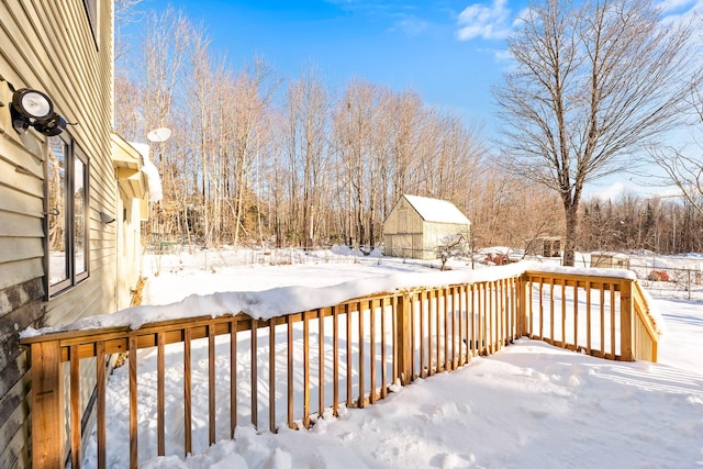 snow covered deck with a storage shed