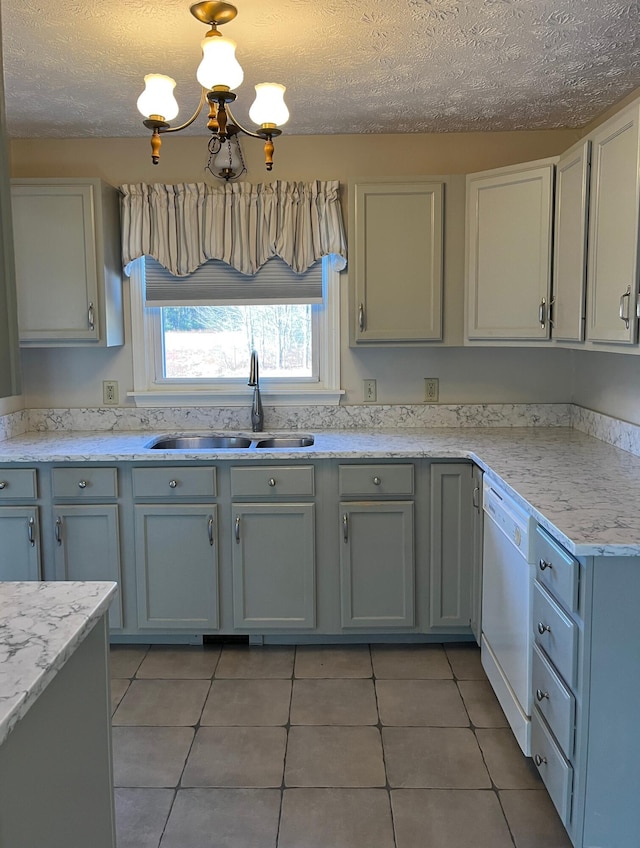 kitchen with dishwasher, light tile patterned floors, a textured ceiling, and sink