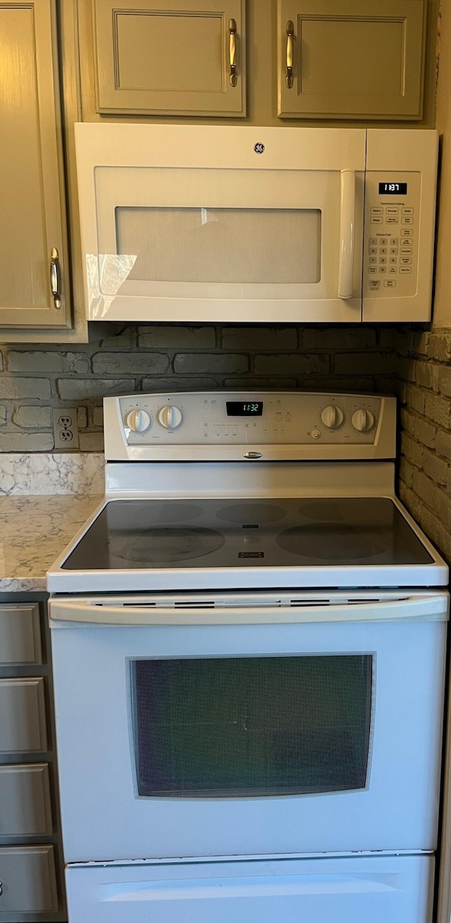 details featuring light stone countertops, white appliances, and tasteful backsplash