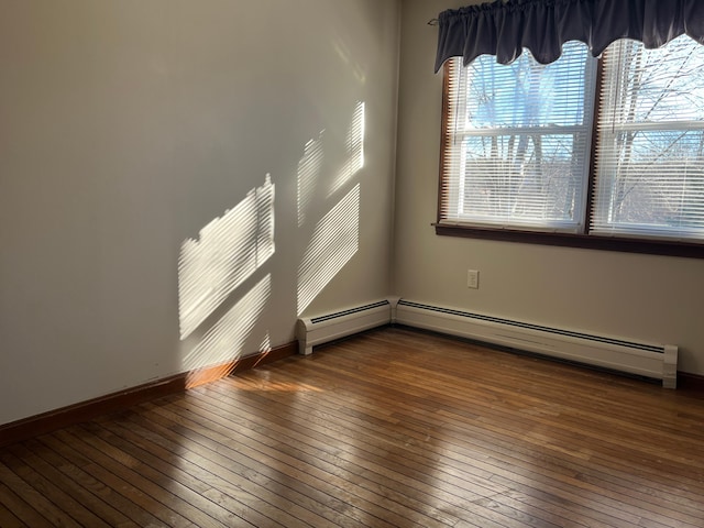 empty room featuring a baseboard radiator and dark hardwood / wood-style floors