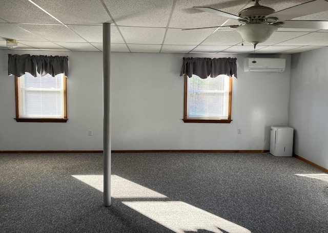 spare room with carpet flooring, a paneled ceiling, a wall mounted AC, and ceiling fan