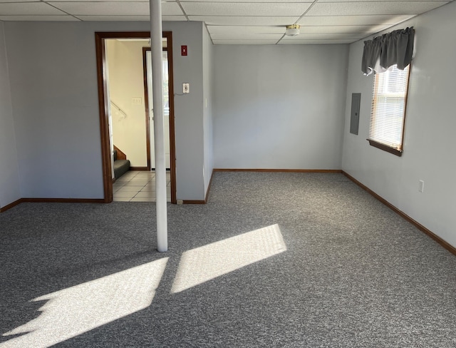 carpeted empty room featuring electric panel and a paneled ceiling