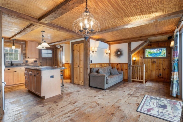 kitchen with decorative light fixtures, a center island, light hardwood / wood-style floors, and light brown cabinets