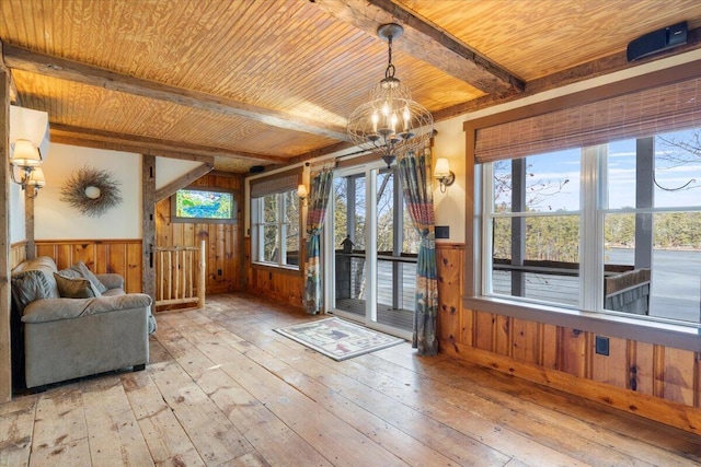 interior space featuring beam ceiling, light wood-type flooring, wooden ceiling, and wood walls