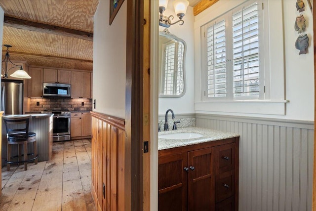 bathroom with beamed ceiling, backsplash, hardwood / wood-style floors, and vanity