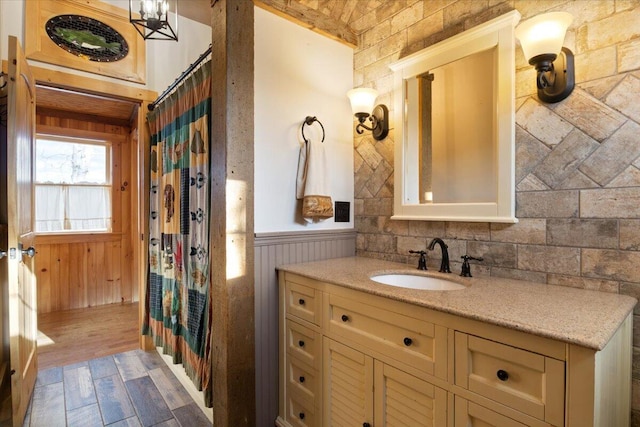 bathroom with vanity, wood walls, and wood-type flooring