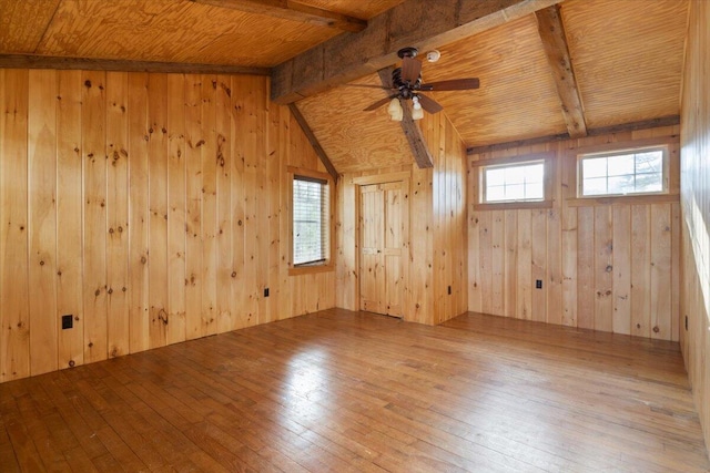 unfurnished room featuring ceiling fan, wooden ceiling, lofted ceiling with beams, wood walls, and wood-type flooring