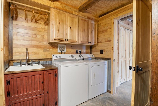 washroom featuring cabinets, separate washer and dryer, wooden walls, and sink