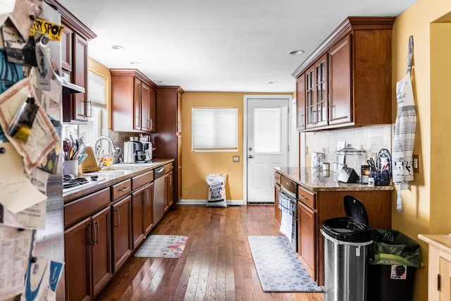 kitchen featuring light stone countertops, sink, dark hardwood / wood-style floors, decorative backsplash, and appliances with stainless steel finishes